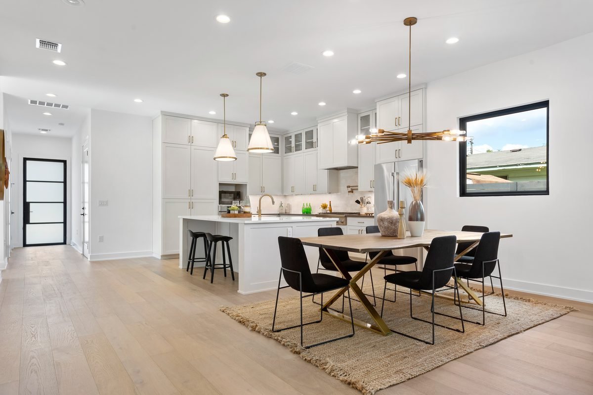 Open concept kitchen and dining area with brass pendant lighting