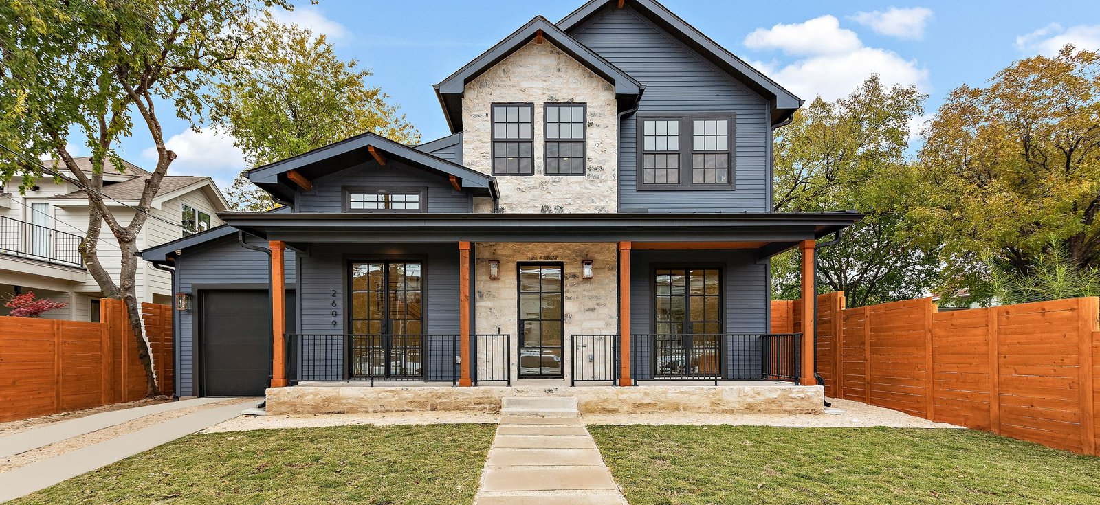 Two-story Hill Country home with stone accents and covered front porch